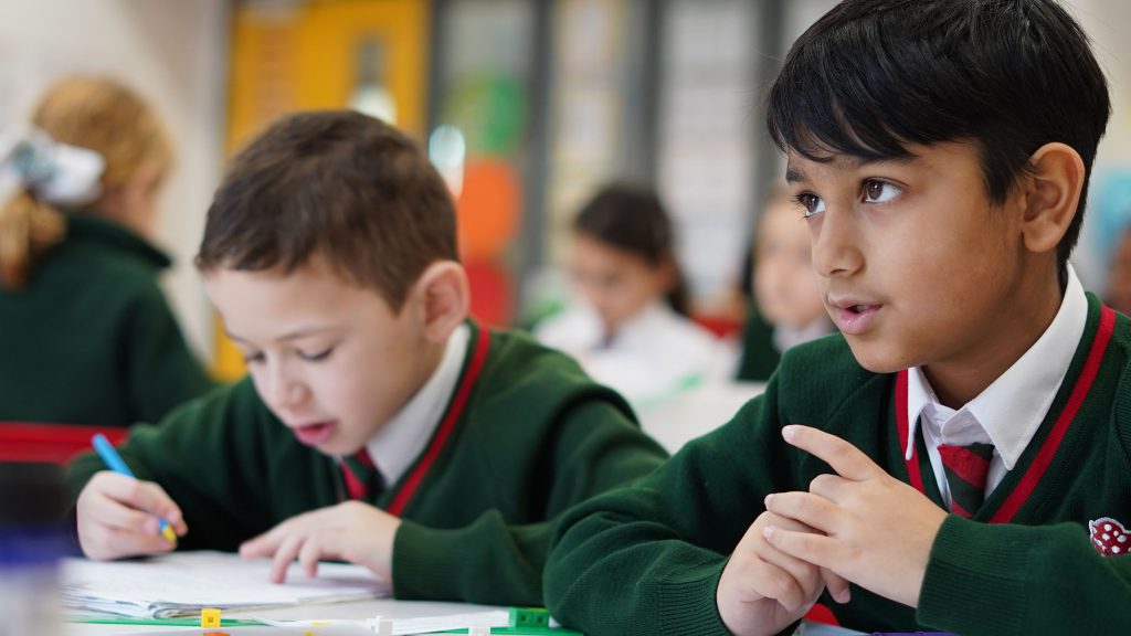 Two students listening to the teacher during a lesson.
