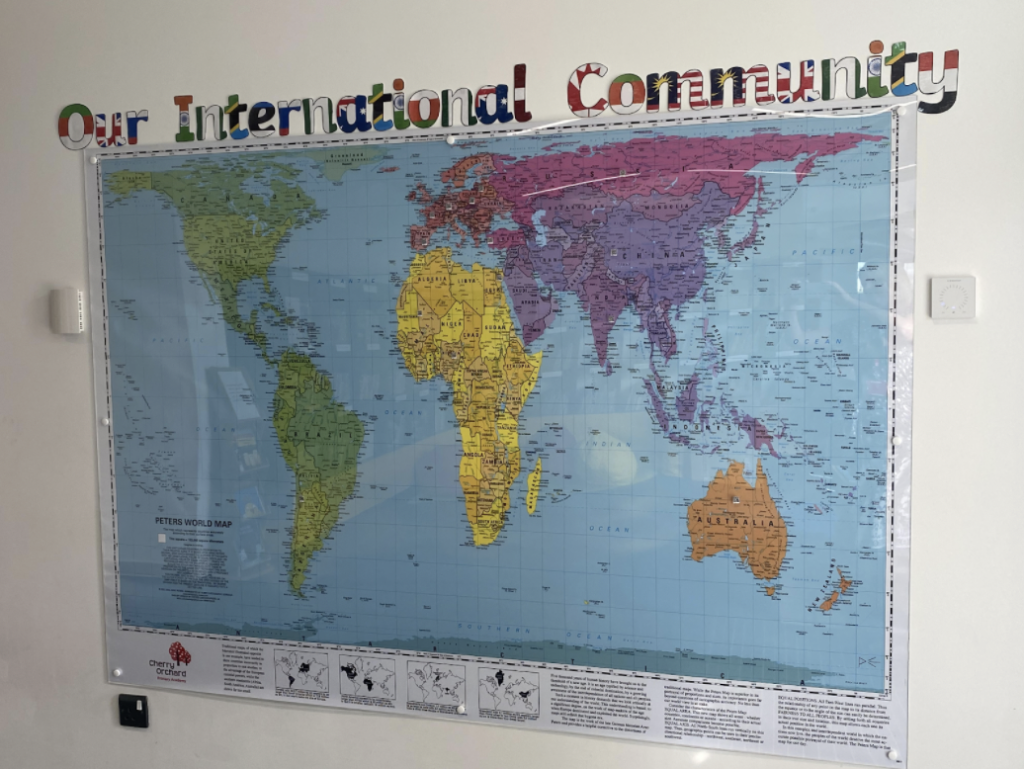 'Our International Community' in text with a map of the world underneath on a poster.